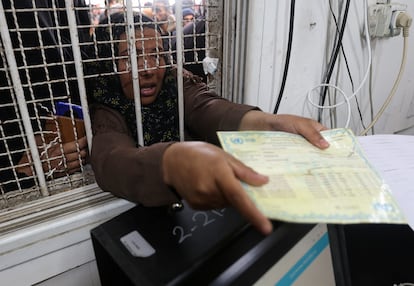 Una mujer palestina presentaba su tarjeta de racionamiento para recibir sacos de harina distribuidas por la Agencia de la ONU para los Refugiados Palestinos (UNRWA), este lunes en Jan Yunis.