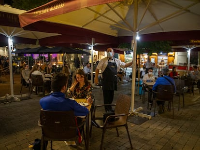 Un camarero enciende unas luces en la terraza de la Cervecería Alemana de la plaza de Santa Ana en Madrid en octubre de 2020.