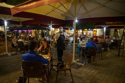 Un camarero enciende unas luces en la terraza de la Cervecería Alemana de la plaza de Santa Ana en Madrid en octubre de 2020.