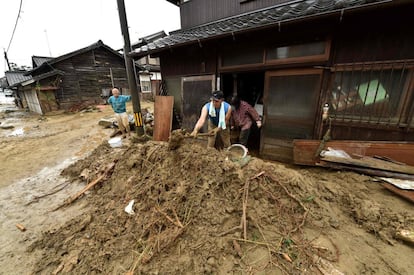 Residentes locales retiran barro de sus casas tras las fuertes lluvias torrenciales en Asakura, el 6 de julio de 2017.