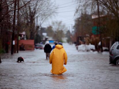 Una persona camina por las calles de la ciudad de La Plata, en Argentina, durante el temporal de este jueves.