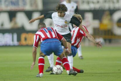 Aimar intenta regatear a varios jugadores del Atlético de Madrid.