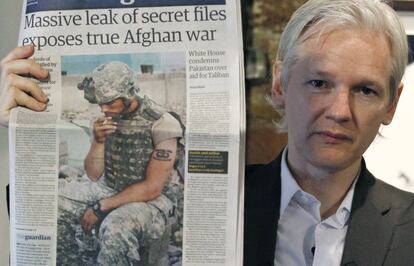 El fundador de Wikileaks, Julian Assange, sostiene la portada de un periódico durante una conferencia de prensa tras filtrarse los documentos militares estadounidenses clasificados sobre la guerra de Afganistán que contenian pruebas de posibles crímenes de guerra, en el Frontline Club, en el centro de Londres, el 26 de julio de 2010.