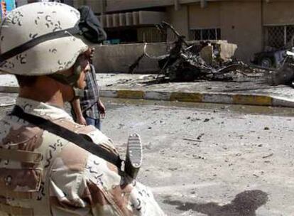 Un soldado iraquí custodia una calle de Bagdad, en la que ha explotado un coche bomba