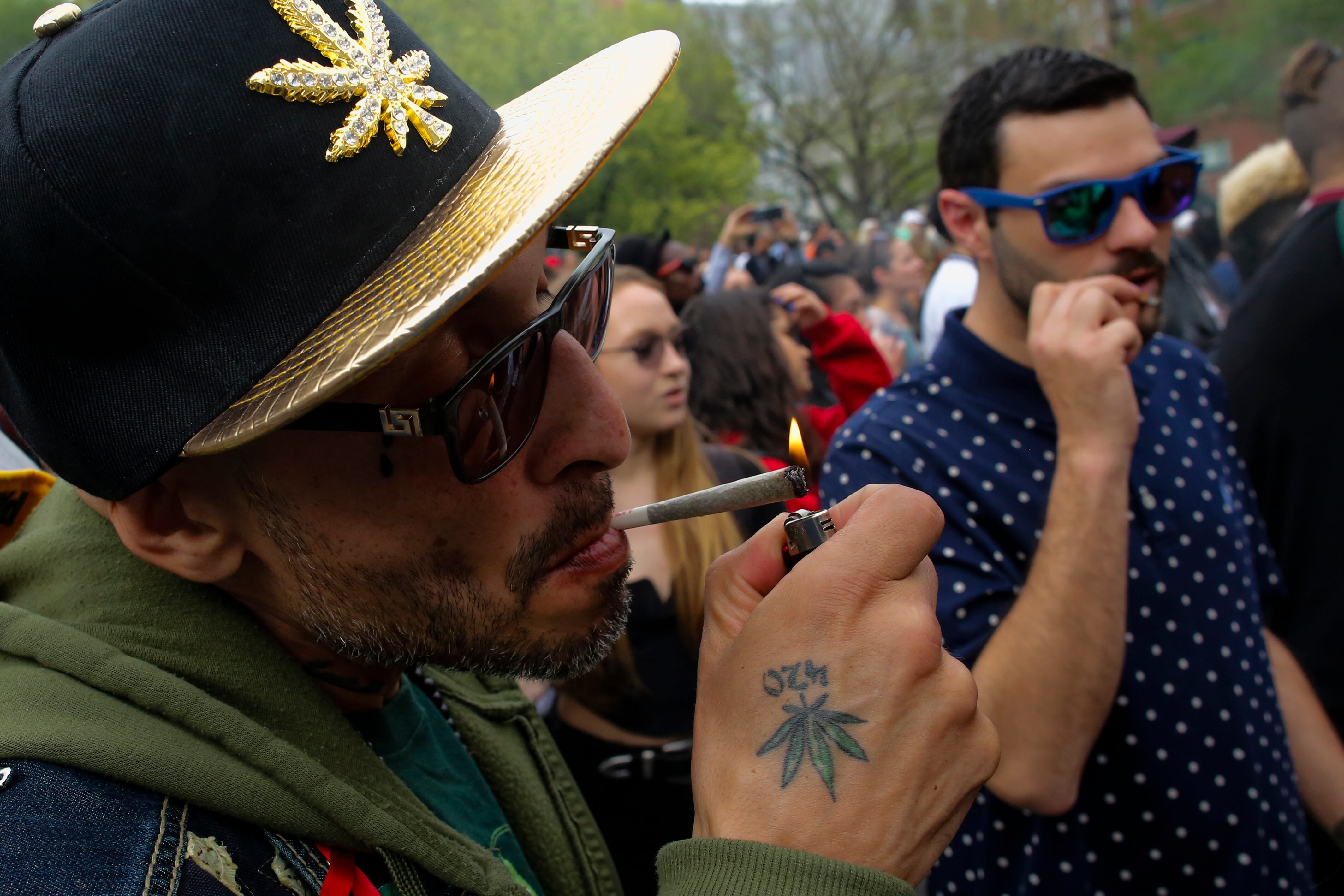 Un hombre enciende un cigarro de marihuana.