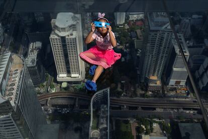 Una niña observa un eclipse solar parcial en en el techo de cristal del edificio King Power Mahanakhon en Bangkok, Tailandia, en junio de 2020.