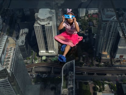 Una niña observa un eclipse solar parcial en en el techo de cristal del edificio King Power Mahanakhon en Bangkok, Tailandia, en junio de 2020.