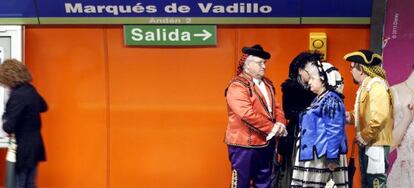 Varios madrile&ntilde;os vestidos de goyescos esperan el metro en la l&iacute;nea 5.