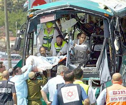 Los servicios de socorro israelíes trasladan el cuerpo de una de las víctimas mortales del atentado contra un autobús, ayer en Meron.