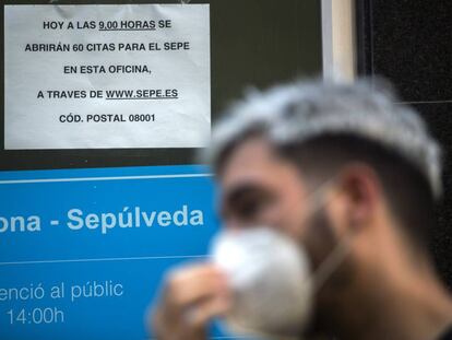 Persona amb mascareta fent cua a l'Oficina de Treball de la Generalitat, a Barcelona.