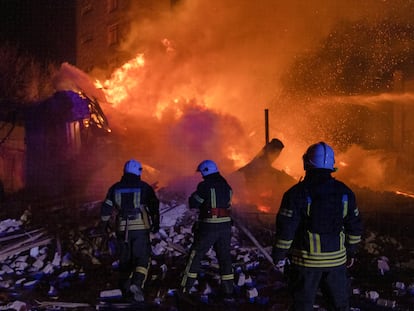Unos bomberos tratan de apagar un incendio provocado por un ataque ruso, este domingo en Járkov.