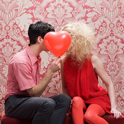 Couple behind heart shaped balloon