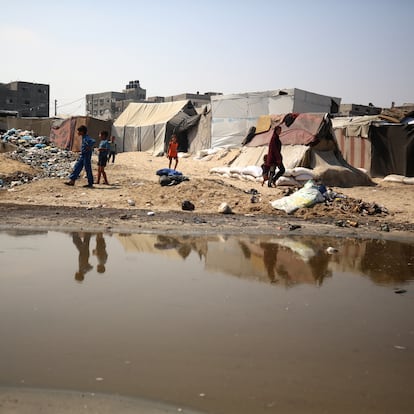 Palestinian displaced people are crossing a beach flooded with sewage water next to their tents in Deir al-Balah in central Gaza Strip, on August 19, 2024, as municipal infrastructure is failing due to Israeli bombardment of the besieged Palestinian territory amid the ongoing conflict with the Hamas movement. (Photo by Majdi Fathi/NurPhoto via Getty Images)