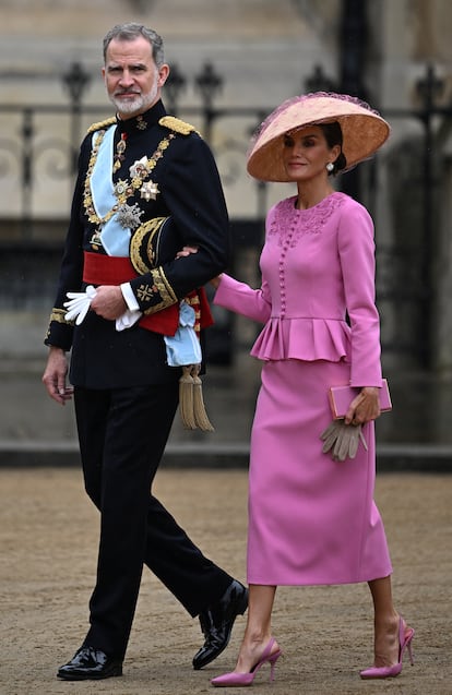 Los reyes Felipe (con uniforme de capitán general del Ejército de Tierra —el mismo que lució en su proclamación— y el Toisón de Oro, la de la Orden de San Jorge y la Jarretera), y Letizia (con un traje compuesto de chaqueta rosa bordada con falda midi, diseño de Carolina Herrera, y un tocado de paja sinamay color arena en forma de pagoda con redecilla rosada de la sombrerería Balel), a su llegada a la abadía de Westminster para la coronación de Carlos y Camila, el 6 de mayo de 2023.