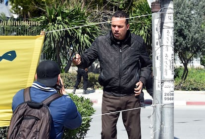 Un policía tunecino apunta con un arma a un fotógrafo que se encuentra en la zona del Museo del Bardo donde se encuentran los atacantes con los rehenes.