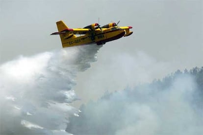 Un avión lanza agua sobre el incendio que afecta al parque natural de Las Quilamas.