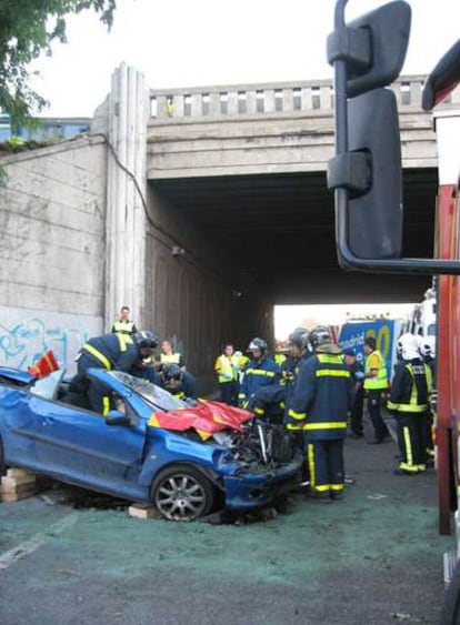 Los bomberos, junto al coche de Fernández Noriega.