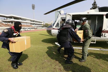 Policías antidisturbios tailandeses cargan cajas de documentos electorales en un helicóptero durante una evacuación de funcionarios electorales desde un estadio deportivo en Bangkok, Tailandia.