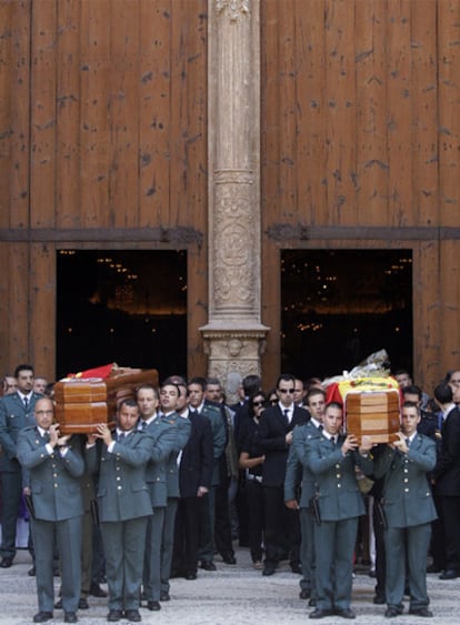 Los féretros de los dos agentes, a hombros de sus compañeros, tras el funeral en la catedral de Palma.