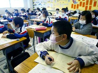 Niños con máscara protectora contra la neumonía, ayer en una escuela de Hong Kong.
