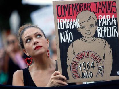 Uma manifestante segura uma placa contra a comemoração do 55º aniversário do golpe militar, no Rio de Janeiro.