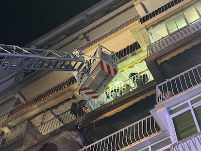 Efectivos de bomberos de la Comunidad de Madrid rescatan a los vecinos de la vivienda en Móstoles donde se ha originado un incendio.
