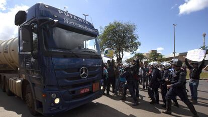  Policías escoltan la salida de camiones con combustible de la distribuidora de Petrobras.