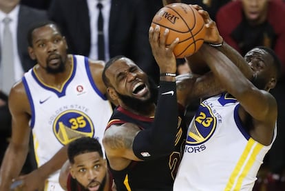 LeBron y Draymond Green pelean por un balón.