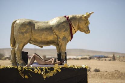 El nudismo está permitido en el festival. En la imagen, un hombre tomando el sol junto a una escultura.