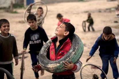 Niños palestinos juegan con ruedas y llantas cerca de Gaza (Palestina).