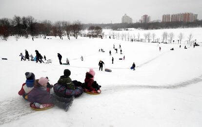 Varios niños montan en trineo y disfrutan de la nieve este martes en Moscú, Rusia.