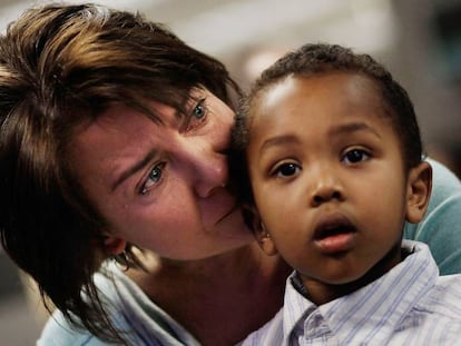 Una mujer llora después de que le concedieran la ciudadanía de EE UU a su hijo adoptivo etíope.
