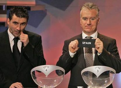 El francés Deschamps, junto al griego Zagarokis, tras extraer la bola de España.