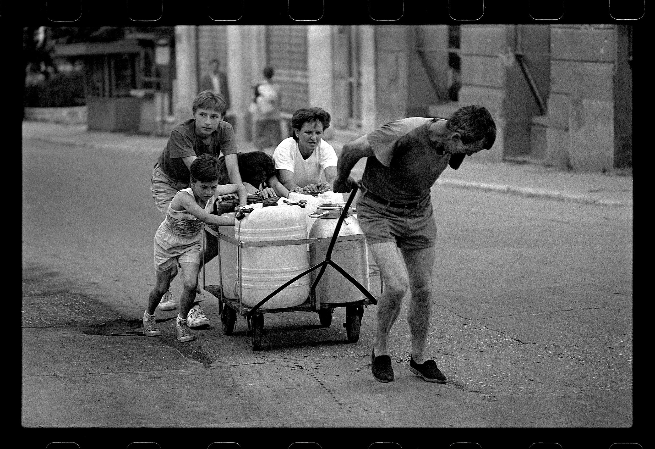 Retrato de una familia empujando un carrito en 'Sarajevo Blues', obra que reúne poesías y prosas del escritor bosnio Semezdin Mehmedinović, con fotografías de Milomir Kovačević.