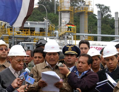 Durante sus primeros meses de mandato, Morales (centro), firmó un "decreto supremo" de nacionalización de los hidrocarburos. En la imagen, Morales lee el decreto en las instalaciones del pozo San Alberto, en una población del sureño departamento de Tarija, el 1 de mayo de 2006. "Se acabó el saqueo de nuestros recursos naturales por empresas extranjeras", dijo.