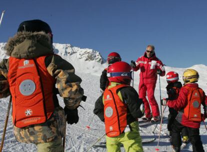 Niños en la estación francesa de Courchevel con chalecos magnéticos que previenen de caídas durante el transporte en los telesillas.