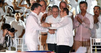 Juan Manuel Santos y Rodrigo Londoño, alias 'Timochenko', se dan la mano ante Raúl Castro.