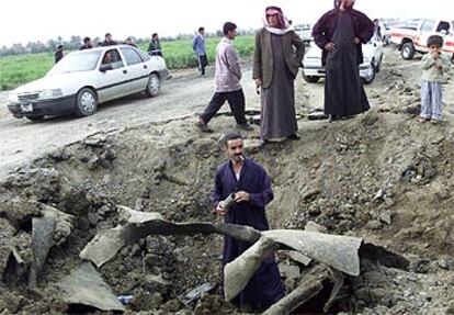 Varios iraquíes observan el tamaño del cráter dejado por la explosión de una bomba en la localidad de Taji.