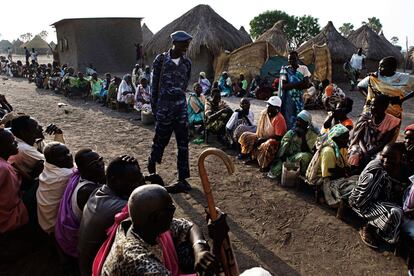 Un policía sudanés camina entre las dos filas de votantes, separados por sexos, a las puertas de un colegio electoral en Dulab, en la provincia del Alto Nilo. Se trata de las primeras elecciones en dos décadas en el mayor país africano.