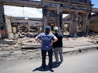 El gobernador de Hawái, Josh Green, a la derecha, y la administradora de FEMA, Deanne Criswell, observan un edificio destruido por las llamas en Lahaina, capital de Maui (Hawái), este sábado.