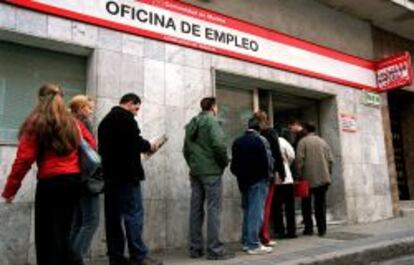 Parados en el exterior de una oficina de empleo.