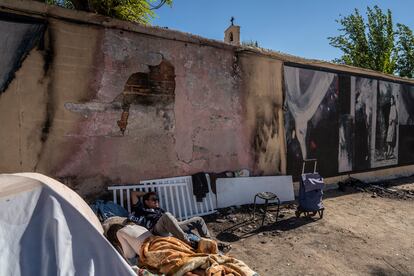 José Camacho, un sintecho nicaragüense que vive en la plaza, dormita bajo el mural, destrozado por las quemaduras.