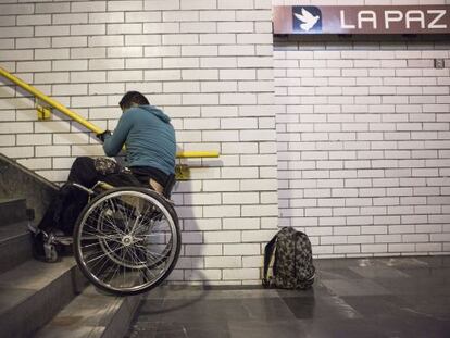 Israel, de 22 años, sube las escaleras del metro de México DF con su silla.