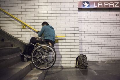 Israel, de 22 años, sube las escaleras del metro de México DF con su silla.