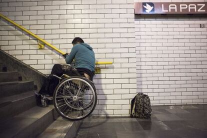 Israel, de 22 años, sube las escaleras del metro de México DF con su silla.