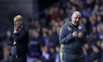 El entrenador del Wigan, Paul Cook, celebra el gol junto a Guardiola.