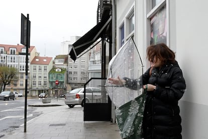 Una mujer abre un paraguas con dificultad por el viento tras el paso de la borrasca Gérard, en A Coruña, Galicia, el lunes.