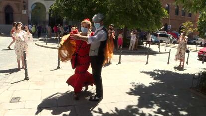 Una pareja vestida de chulapos bailando frente a la iglesia de la Virgen de la Paloma y San Pedro el Real en el día de su fiesta, en agosto.