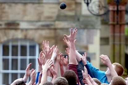 Decenas de jóvenes persiguen la pelota durante el evento anual 'Fastern Eve Handba' en una calle de la localidad escocesa de Jedburgh.