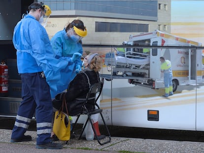 Unos enfermeros realizan un test a una mujer en el exterior de una de las doce unidades móviles que la Junta de Castilla y León ha contratado para hacer test de antígenos a la población que tenga síntomas durante todo el mes de enero, este martes en Valladolid.